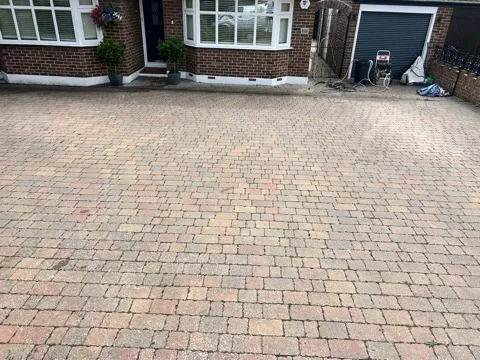 Clean block-paved driveway in front of a brick bungalow