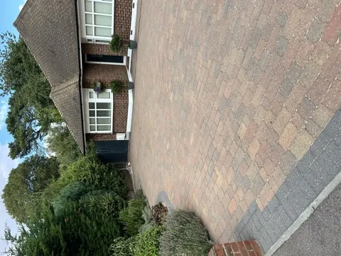 Block-paved driveway with garden border and brick bungalow