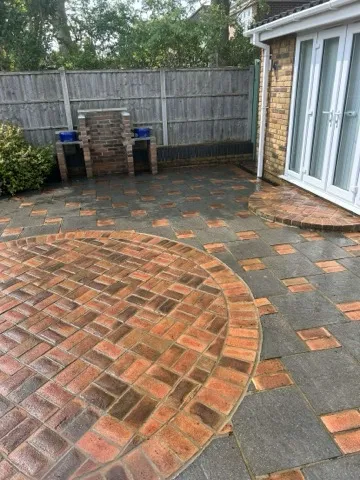 Decorative circular patio with grey slabs and brick detail